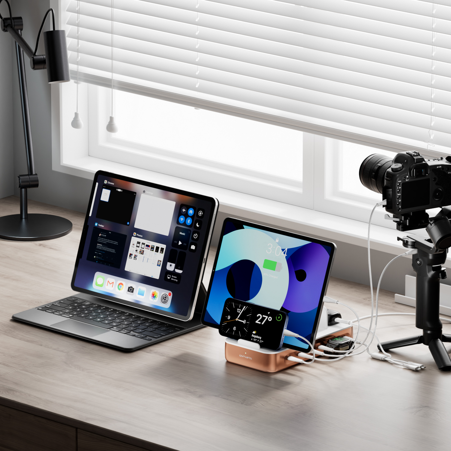 The 4smarts charging station Team on a desk, connected to a tablet, a smartphone, a smartwatch and a camera. The devices are charged simultaneously, while the charging station keeps the cables neatly organized.