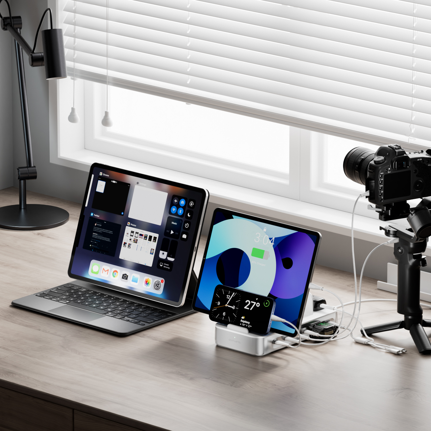 The 4smarts charging station Team on a desk, connected to a tablet, a smartphone, a smartwatch and a camera. The devices are charged simultaneously, while the charging station keeps the cables neatly organized.