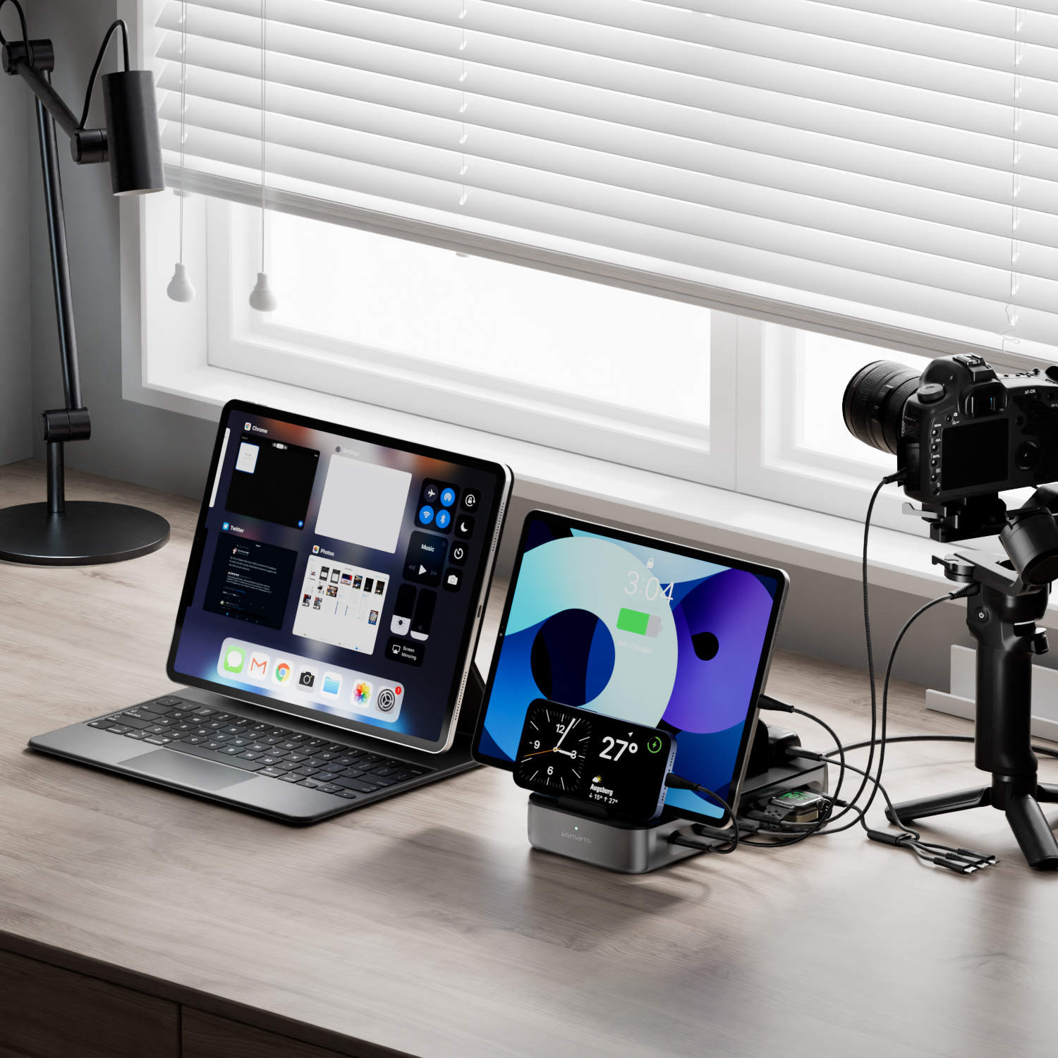 Die 4smarts Ladestation Team auf einem Schreibtisch, verbunden mit einem Tablet, einem Smartphone, einer Smartwatch und einer Kamera. Die Geräte werden gleichzeitig geladen, während die Ladestation die Kabel ordentlich organisiert.
